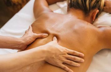 Massothérapeute pratiquant un massage relaxant du dos et des épaules sur un client allongé