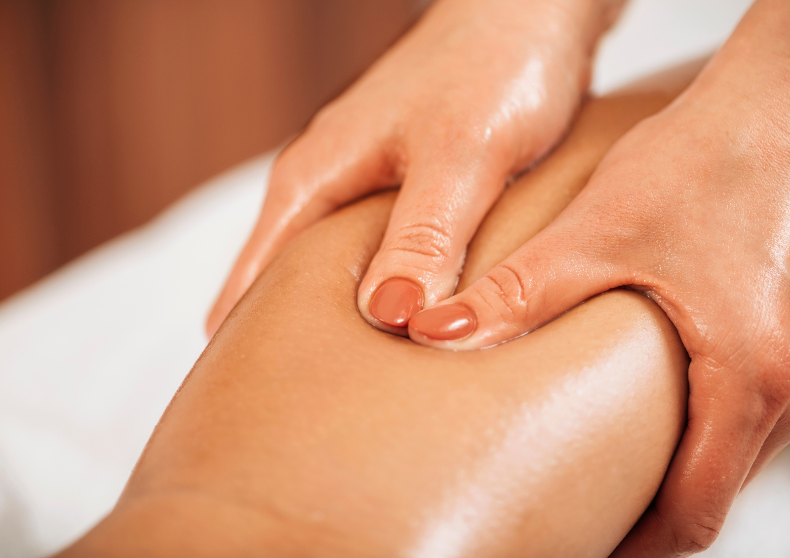 Mains effectuant un massage bien-être sur l'épaule et le dos d'une personne allongée